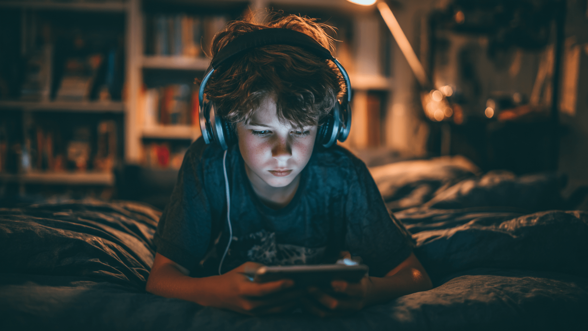 Pojke med hörlurar och läsplatta