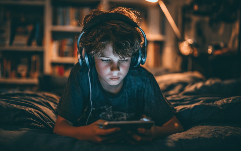 Pojke med hörlurar och läsplatta